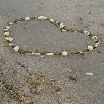 drawing heart on the sand in the beach