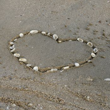 drawing heart on the sand in the beach