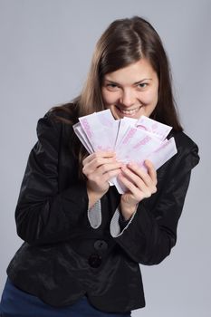 Young long-haired woman holding euros in a fan-shape in his hand