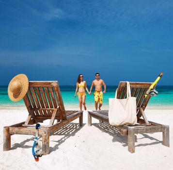 Couple in yellow running on a tropical beach at Maldives