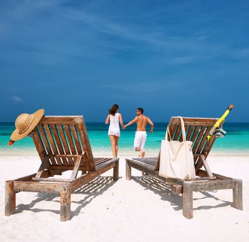 Couple in white running on a tropical beach at Maldives