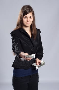 Young long-haired woman holding dollars and offered money