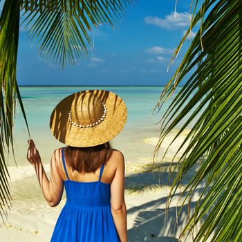 Woman in blue dress on a tropical beach at Maldives