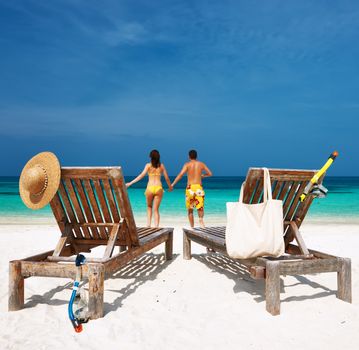 Couple in yellow running on a tropical beach at Maldives