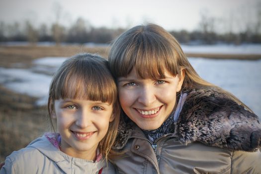 Happy mother and daughter laughing together outdoors