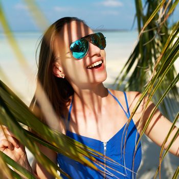 Woman in blue dress on a tropical beach at Maldives