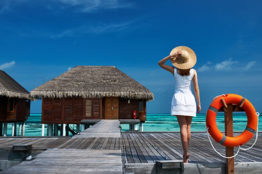 Woman on a tropical beach jetty at Maldives