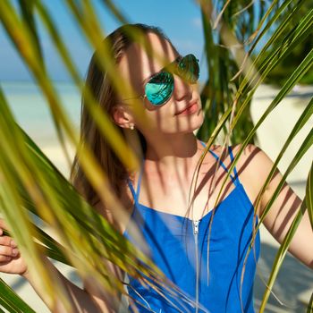 Woman in blue dress on a tropical beach at Maldives