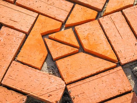 Closeup of orange brick paving stones pattern in the construction process