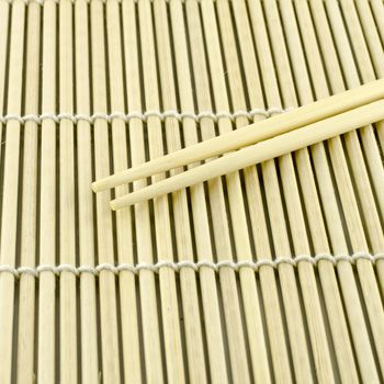 Two chopsticks on sushi mat background for menu