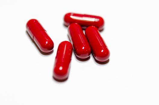 The medicine red capsules on white background.
