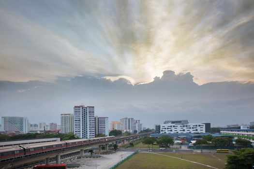 Sunset with Sun Rays Over Singapore Housing Estate by the MRT Train Track
