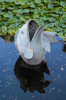 Metal Fish Statue on a Dark Pond