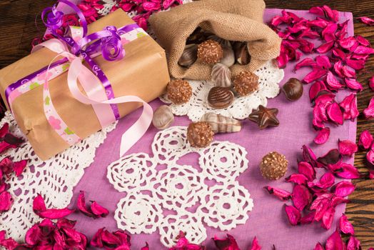 Valentines gift in a still life with flower petals and treats