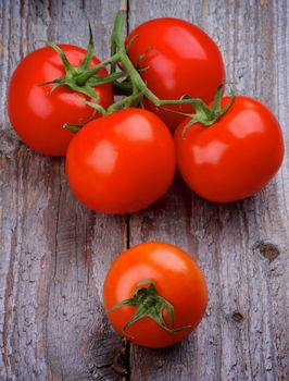 Arrangement of Ripe Tomatoes with Stems isolated on Rustic Wooden background