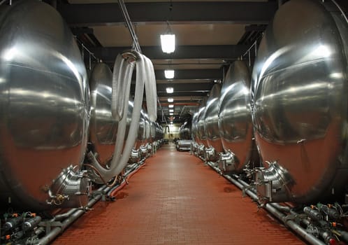 Two lines of beer vats in a factory.