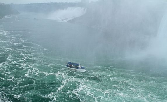 Tourists ride a boat to Niagara Falls.