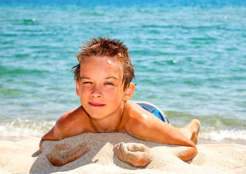 Happy boy enjoying summer day on a beach