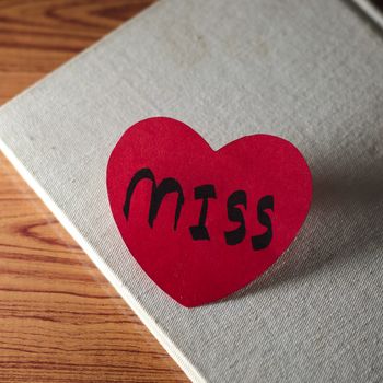 diary of love with notebook and heart on wood background