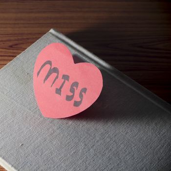 diary of love with notebook and heart on wood background