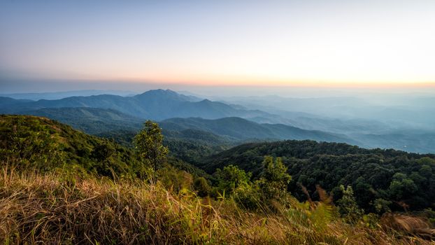 landscape of high mountain with sunset at horizon of sky and lens flare effect