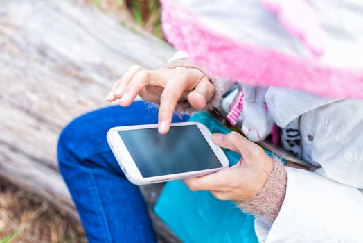 finger of girl touching screen on mobile phone