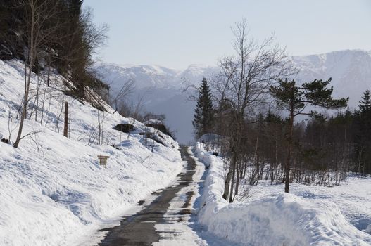 A snow plowed narrow country road in Norway