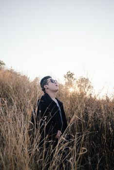 Vintage photo of young man with sunrise in grass field morning time