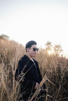 Vintage photo of young man with sunrise in grass field morning time