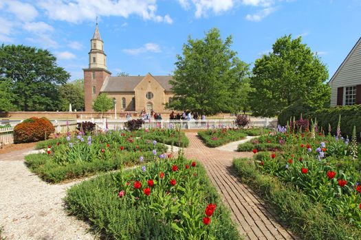 WILLIAMSBURG, VIRGINIA - APRIL 21 2012: Gardens of Colonial Williamsburg in front of Bruton Parish Church in spring. The restored town is a major attraction for tourists and meetings of world leaders.
