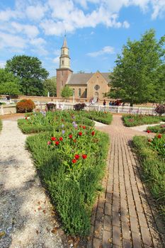 WILLIAMSBURG, VIRGINIA - APRIL 21 2012: Gardens of Colonial Williamsburg in front of Bruton Parish Church in spring. The restored town is a major attraction for tourists and meetings of world leaders.