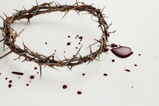 Crown of thorns with blood over white background.