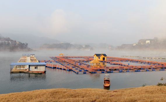 Landscape of floating house on a lake in a foggy morning