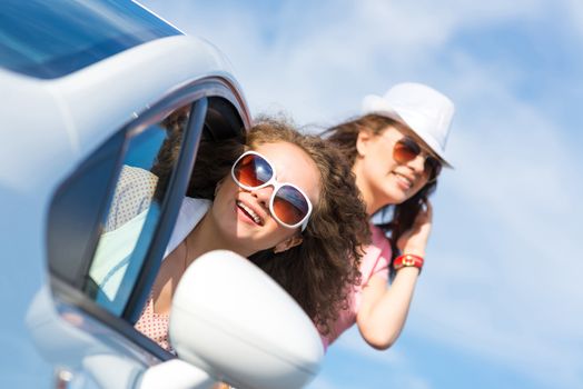 young attractive woman in sunglasses got out of the car window and laugh