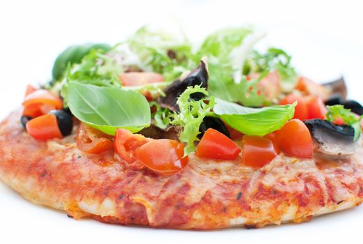 Close up of a deep pan pizza topped with mushrooms, basil and tomatoes 