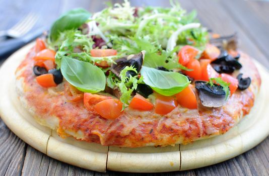 Gourmet deep pan pizza topped with tomatoes, basil and mushrooms