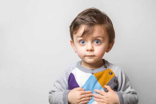 Child with his hands on the chest with a funny look