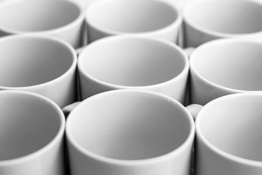 Beautiful group of white mugs over white glossy surface