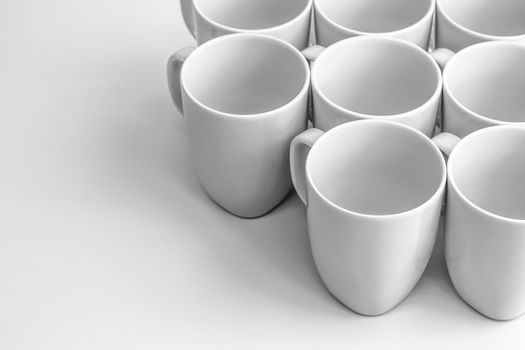 Beautiful group of white mugs over white glossy surface