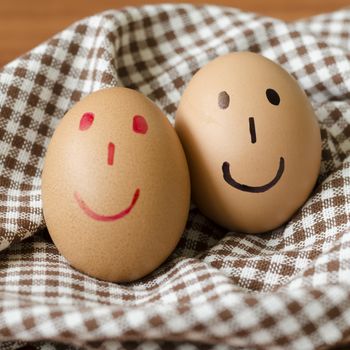 smile love egg couple in brown kitchen towel on wood table