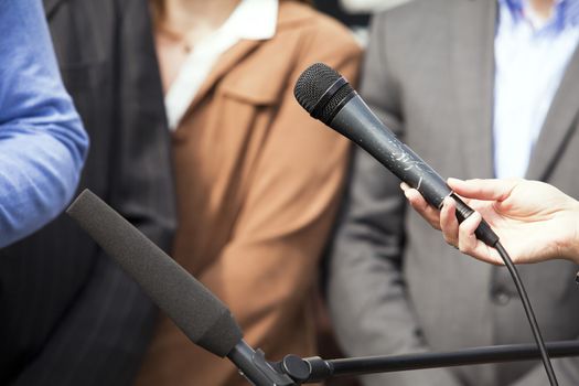 Journalist hand holding a microphone conducting an TV or radio interview