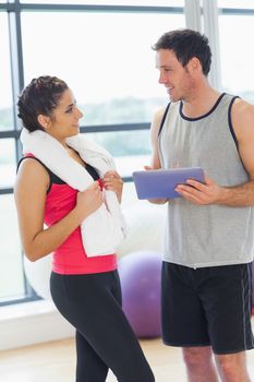 Fit young couple with at digital table in a bright exercise room