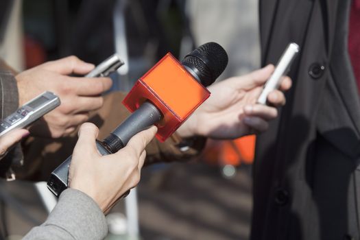 Journalist hand holding a microphone conducting an TV or radio interview