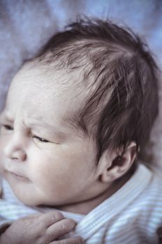 new born baby curled up sleeping on a blanket, multiple expressions