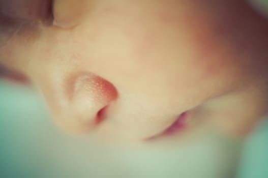 Newborn peacefully sleeping, picture of a baby curled up sleeping on a blanket