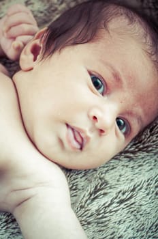 Newborn peacefully sleeping, picture of a baby curled up sleeping on a blanket