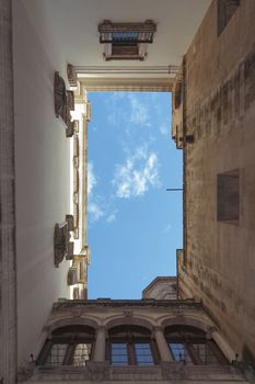 blue sky tightly surrounded by medieval buildings  inside famous Barri Gothic Quarter in Barcelona