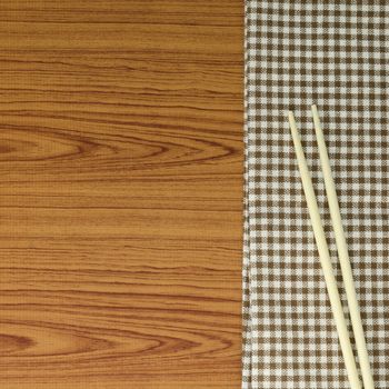 chopsticks with kitchen towel on wood background