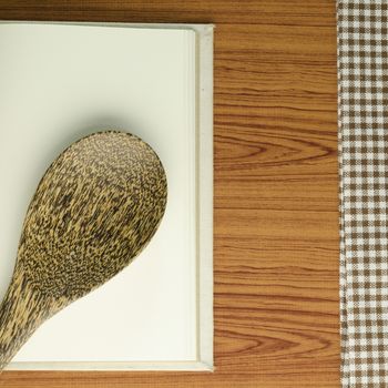 brown kitchen towel with spoon on wood background