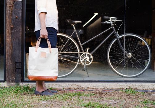 Man with canvas bag and vintage bicycle on background
